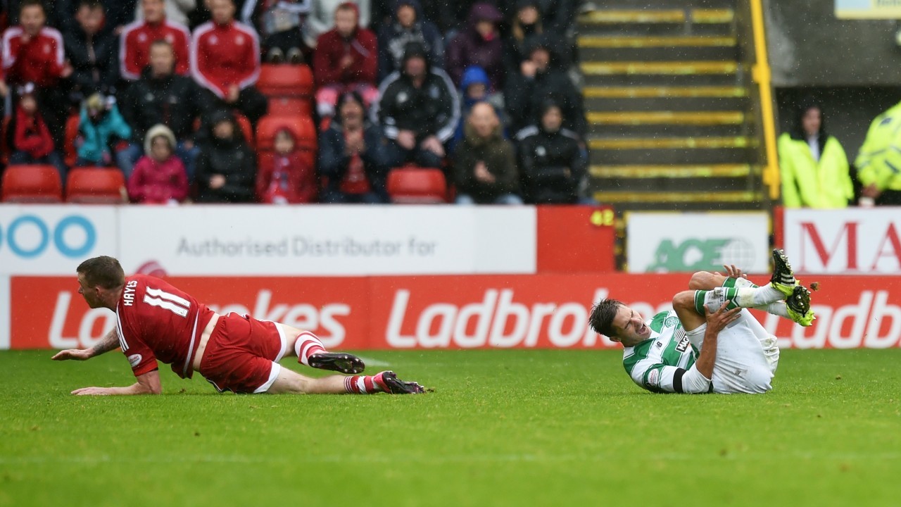 Celtic's Mikael Lustig (right) clutches his leg after being tackled by Jonny Hayes which sees the Aberdeen player receive a red card