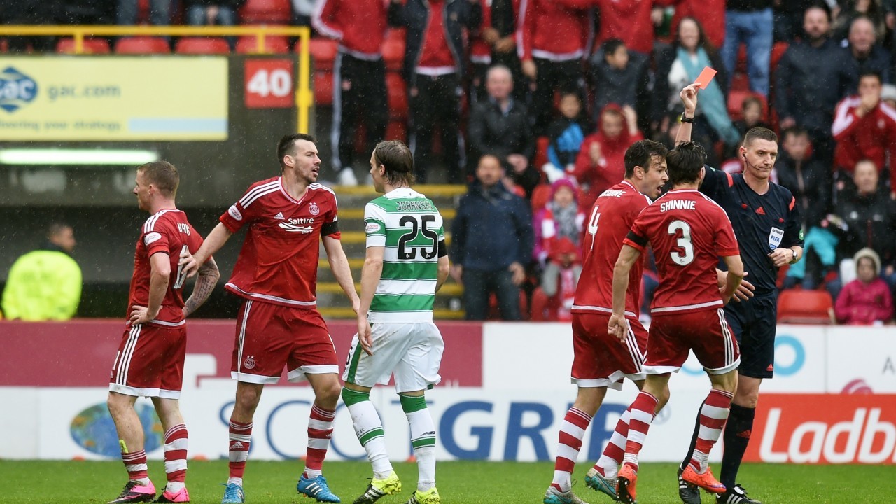 Referee Craig Thomson (right) brandishes a red card to Aberdeen's Jonny Hayes