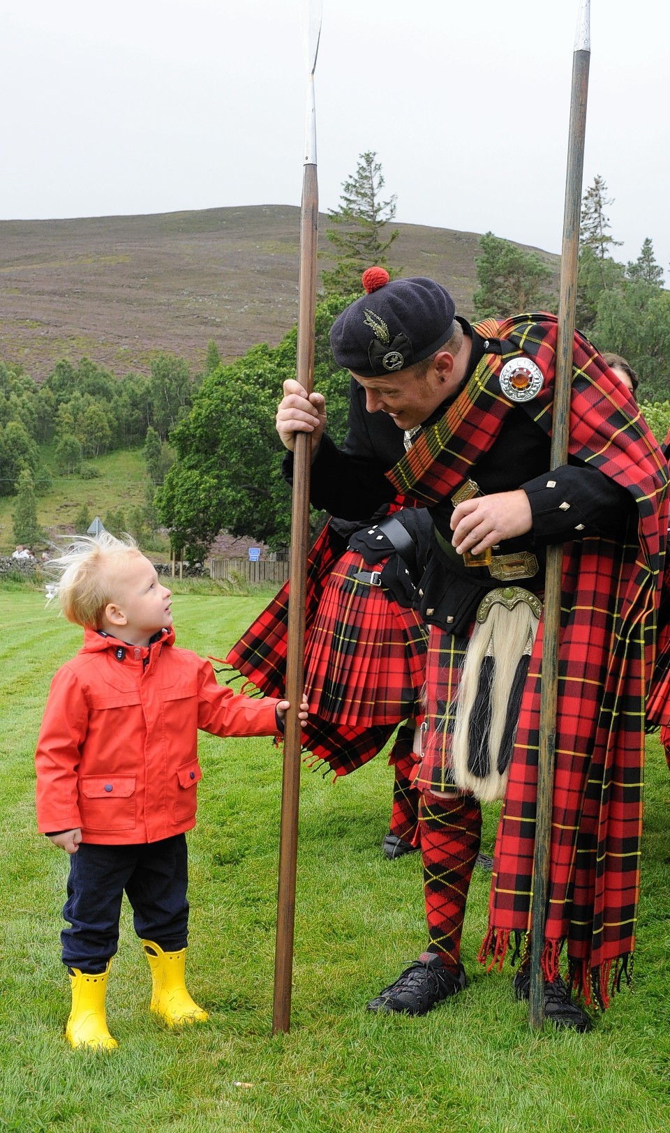 A Lonach Highlander chats to one of Gairnshiel Lodge's younger holiday-makers