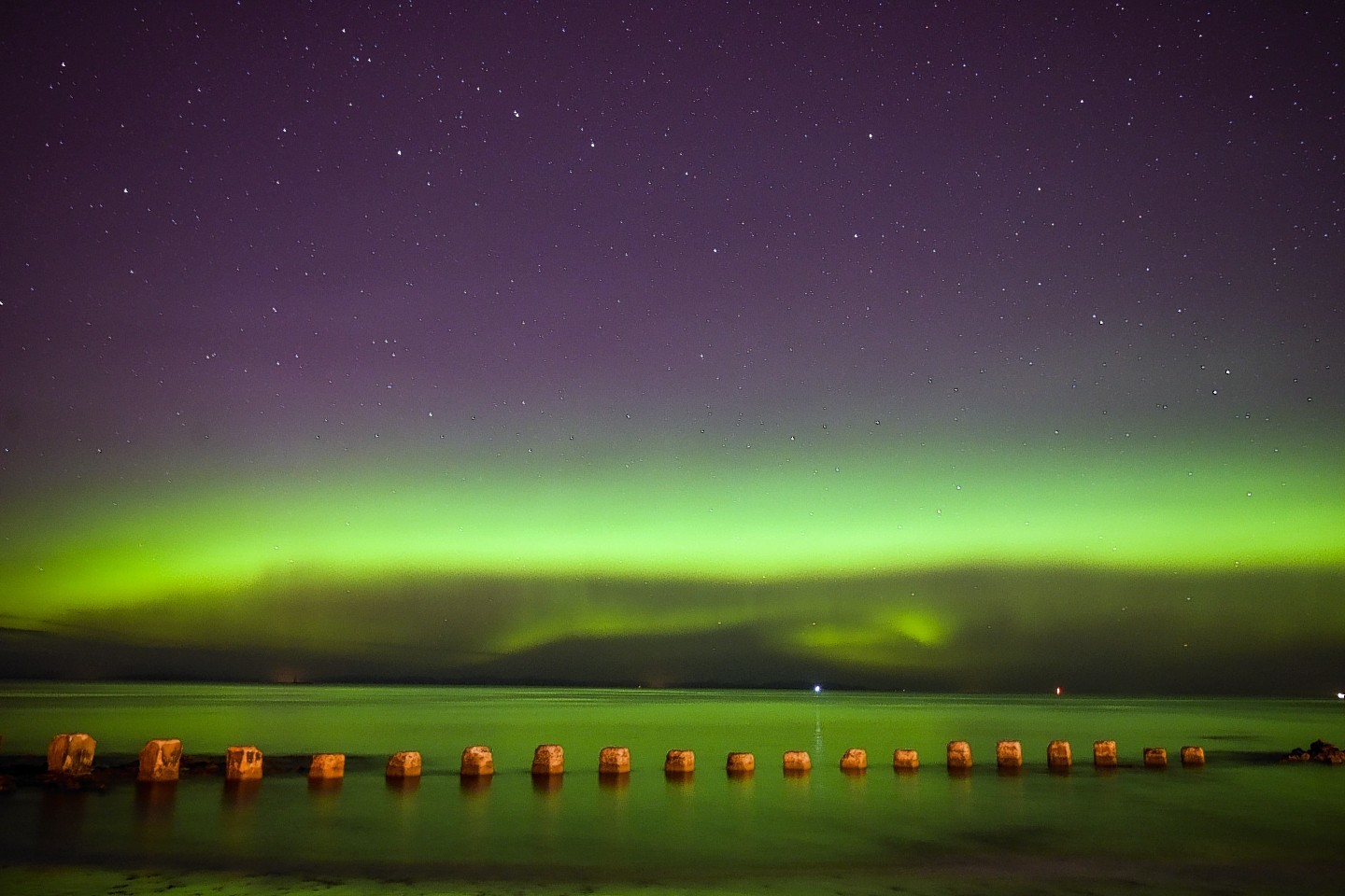 The Aurora Borealis, also known as the Northern Lights, are seen lighting up the sea by the West Beach in Lossiemouth, Moray