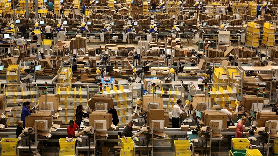 Workers packing orders on the warehouse floor at the Amazon UK Fulfilment Centre in Peterborough