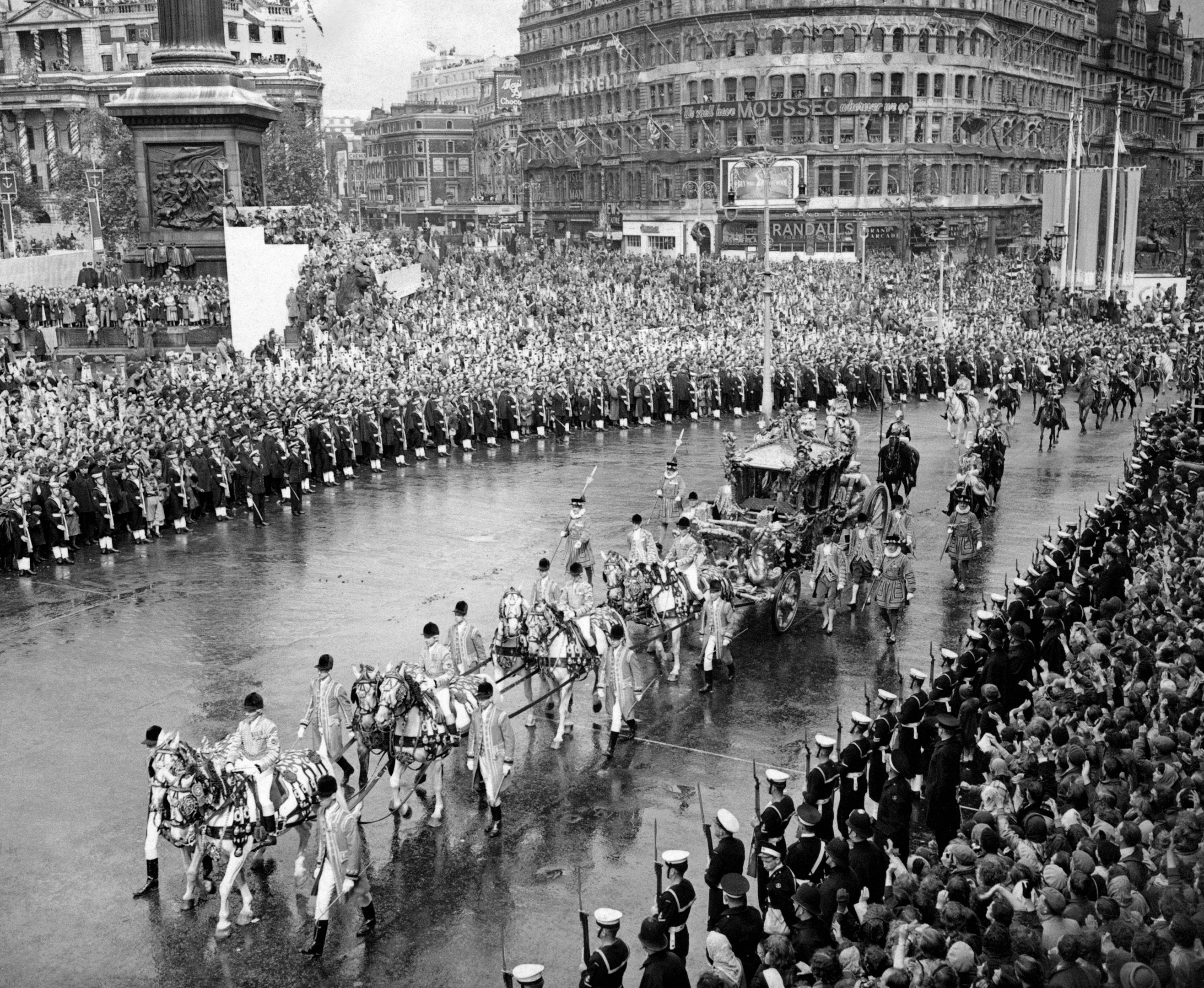 The golden State coach, bearing the Queen and the Duke of Edinburgh, passes through the cheering crowds which, despite the rain, packed Trafalgar Square to greet the sovereign on her from Westminster Abbey to Buckingham Palace after her Coronation.