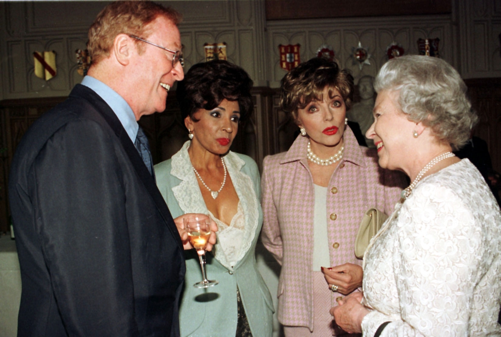 Left to right: Actor, Michael Caine; singer Shirley Bassey and actress, Joan Collins chat to the Queen during a reception for the British Arts at Windsor Castle 