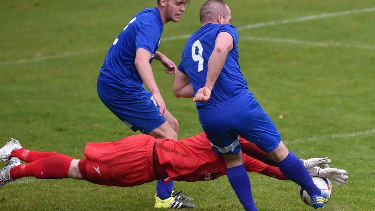 Brave Huntly keeper Fraser Hobday throws his face in front of man, ball and boot to deny Rothes' Mateusz Bobrowski