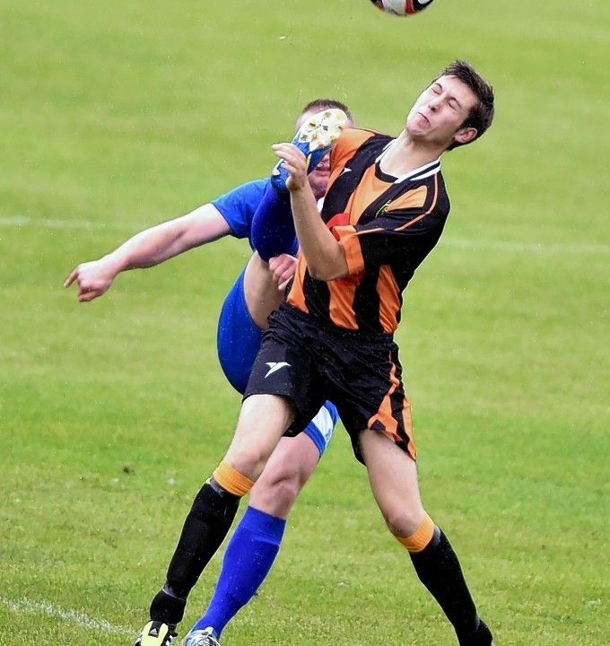Huntly Michael Clark sees the boot of Rothes Kyle Gauld.