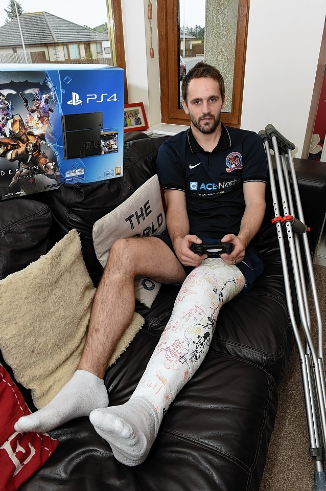 Turriff United defender Stuart Cumming recuperating at home in New Deer, with the help of a new play-station 4 bought by his team-mates to aid his recovery. Picture by Kevin Emslie