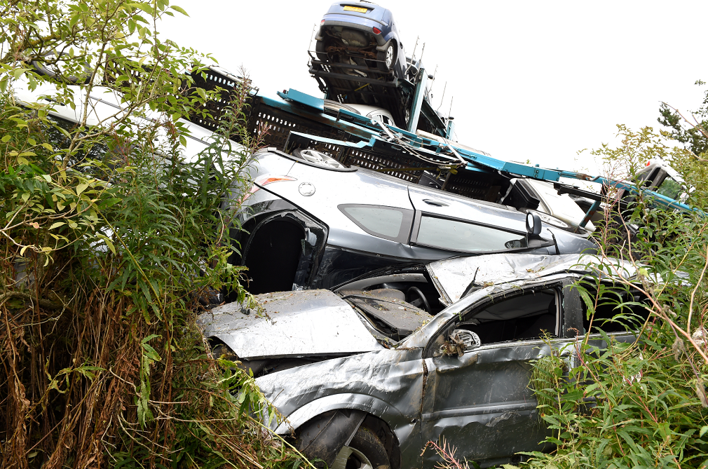 The crash left a number of cars that were being transported severely damaged.