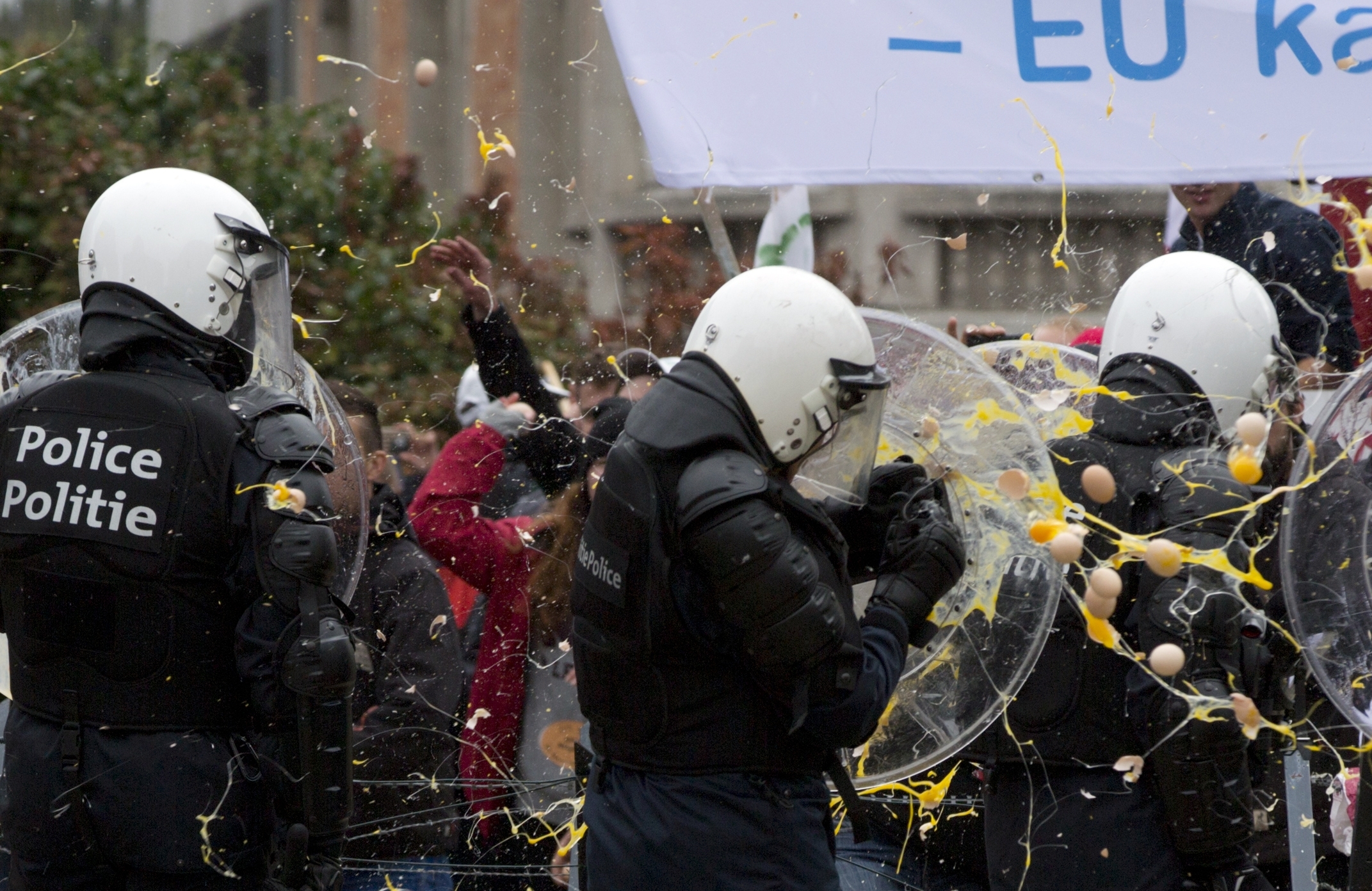 Riot police are hit with eggs during a farmers demonstration 