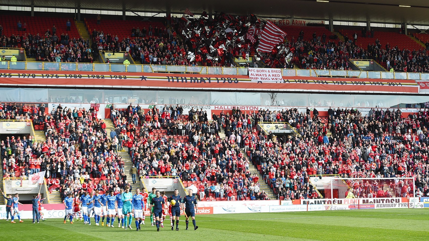 Players walk out at Pittodrie as fans pay tribute to Dons fan, Kevin Bartlet.