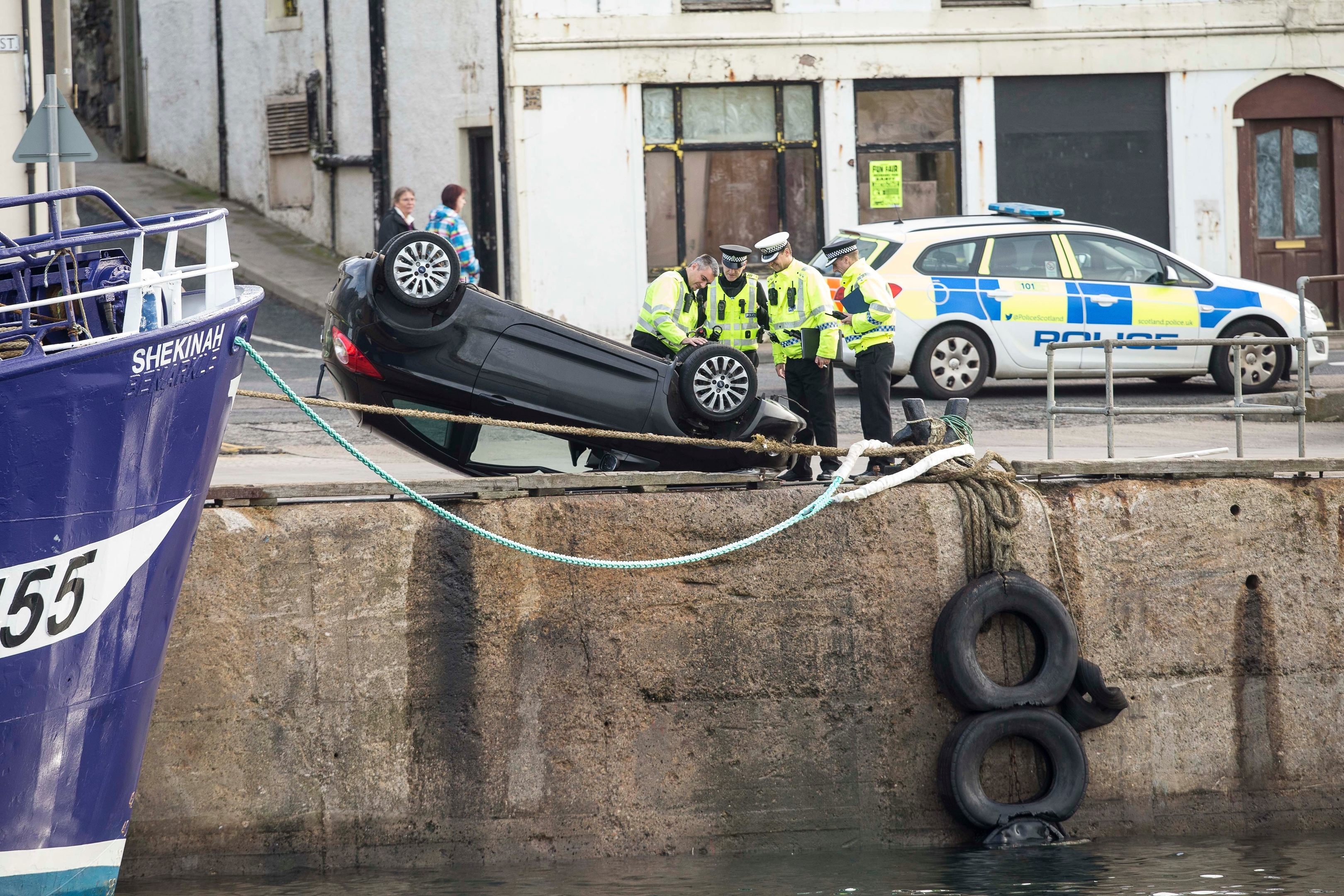 Officers with the car that entered the harbour