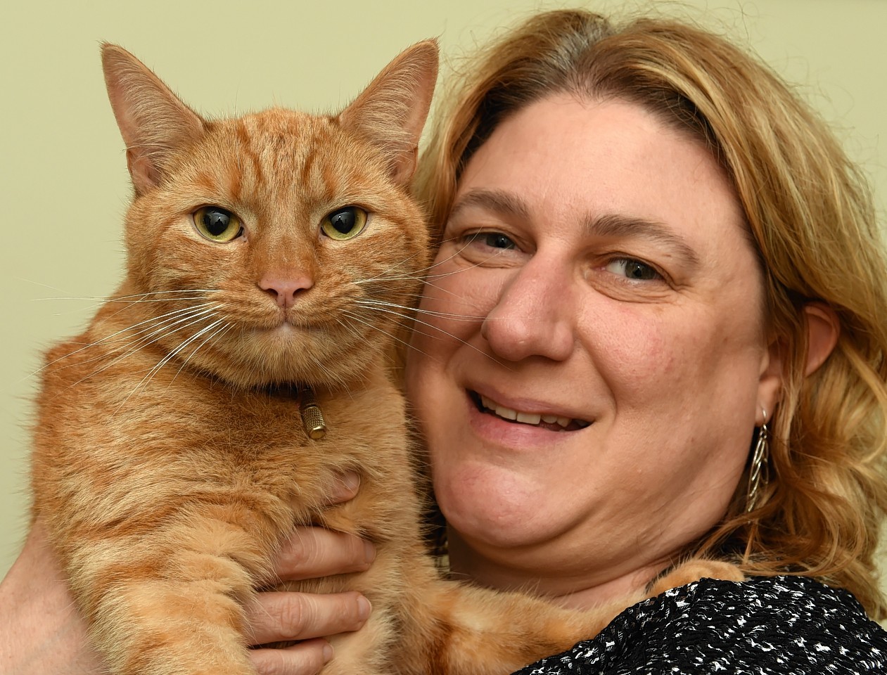 Helen Costin with her cat, Toffee, after he got miraculously stuck on the roof of a three-storey Aberdeen building