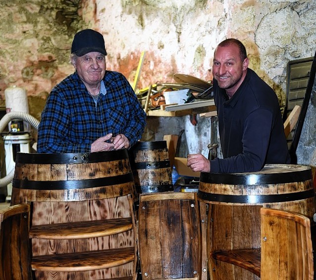 Colin McBain, left, and Donald McBain, right, with old barrels recycled as cabinets