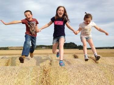Claire Rhind sent in this picture of her three children - Grant, Rhona and Maria - playing in the field while their Dad finished combining.