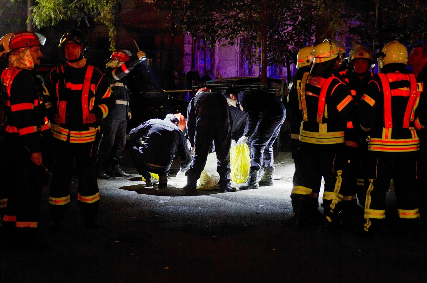 Forensic workers collect items outside the site of an explosion that occurred  in a club in Bucharest