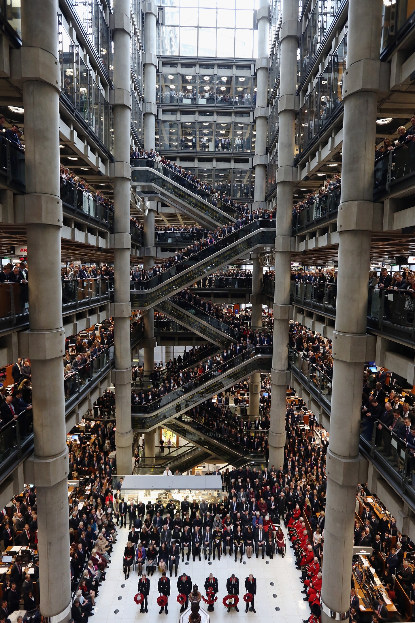  Brokers and underwriters line the balconies and escalators of the Lloyd's of London building during a service of Remembrance on November 11, 2015 in London, England. The annual Armistice Day service honours those who have lost their lives during times of war. The service at Lloyd's is observed with the ringing of the Lutine Bell, the laying of wreaths before the Book of Remembrance and a two minute silence. 