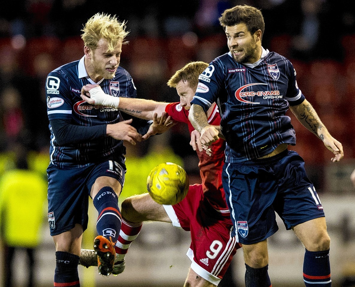 Ross County pair Andrew Davies (left) and Richard Foster battle with Adam Rooney
