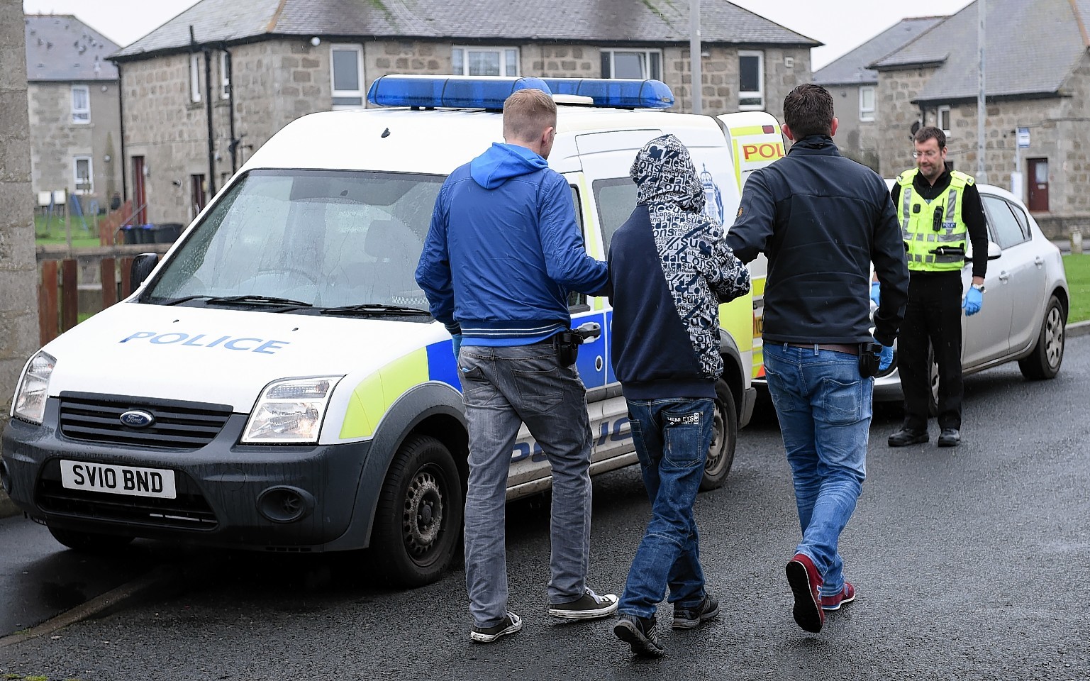 Police lead a suspect away following one of the raids