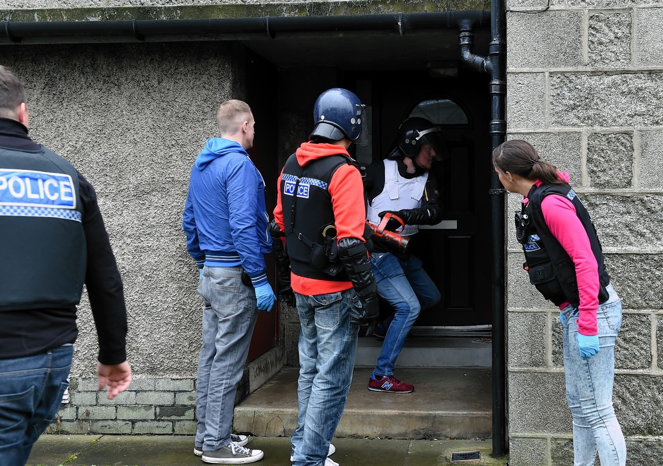 Police break down the door of a Fraserburgh home in a series of raids