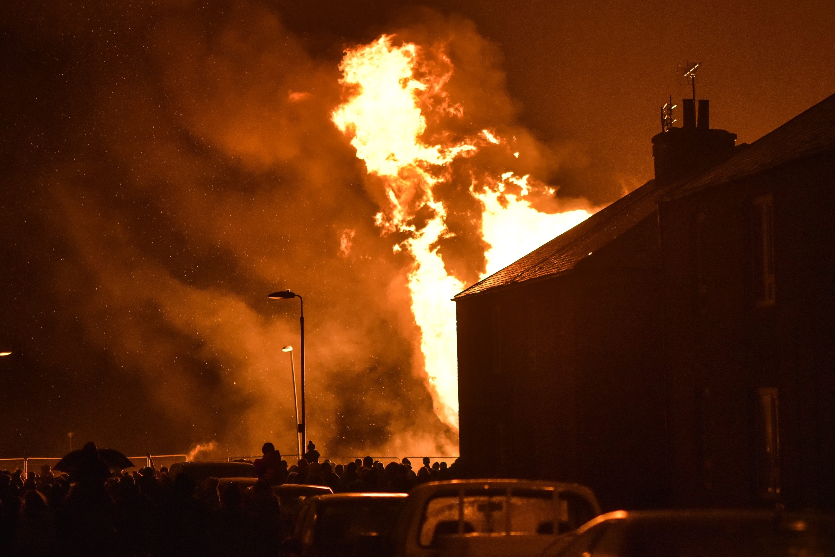 Members of the public gather to watch the bonfire in Peterhead, Aberdeenshire on November 05 2015. Events are being held across the country tonight, Thurs November 05, to mark Guy Fawkes Day. The bonfire in Peterhead, Aberdeenshire, which is created by pallets and other large wooden objects, is thought to be one of the biggest in Scotland. It's estimated to stand at over 20 feet tall.