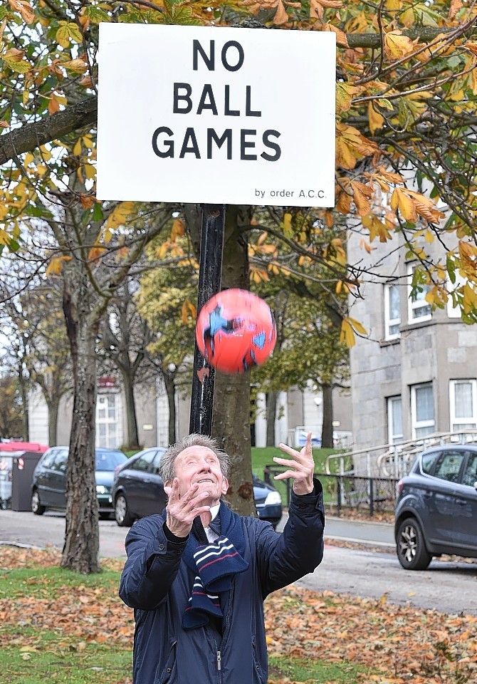 Denis Law visited the city to remove one of the No Ball Games signs at Powis today. Picture by Colin Rennie