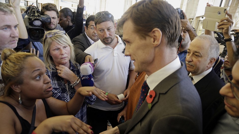 UK ambassador to Egypt, John Casson, talks to British tourists in Sharm el-Sheikh airport (AP)