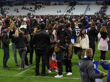 Spectators gather on the pitch of the Stade de France stadium following  the International Friendly match between France and Germany at the Stade de France