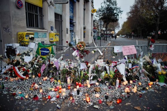 Floweres, candles and tributes cover the pavement near the scene of Friday's Bataclan Theatre terrorist attack