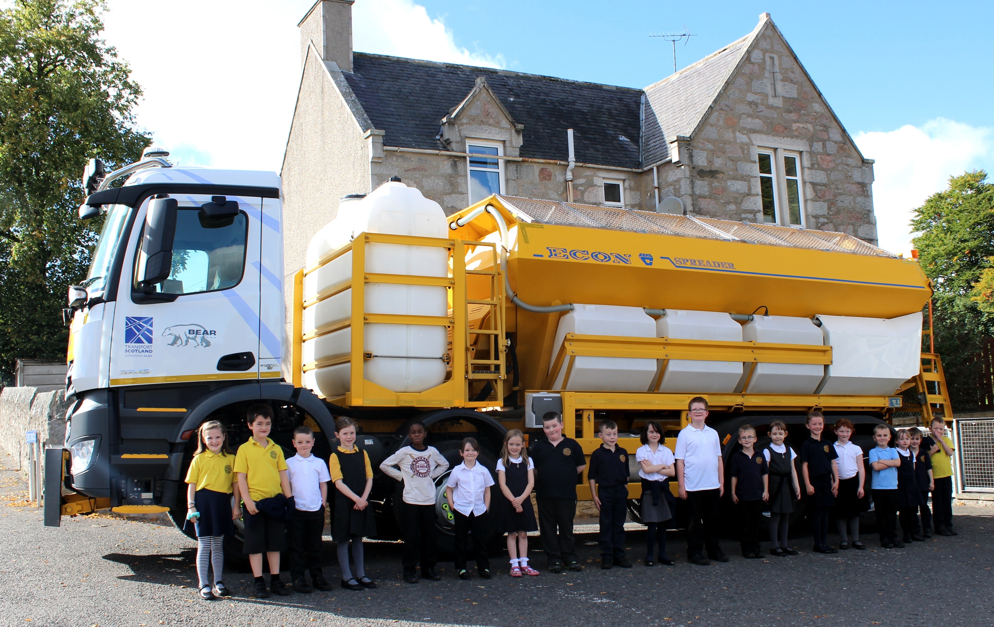 Pupils from Port Elphinstone primary school posing next to one of BEAR Scotland's gritters