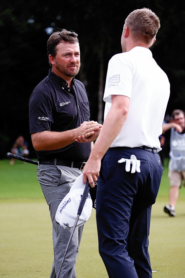 Russell Knox congratulates Graeme McDowell on the 18th hole