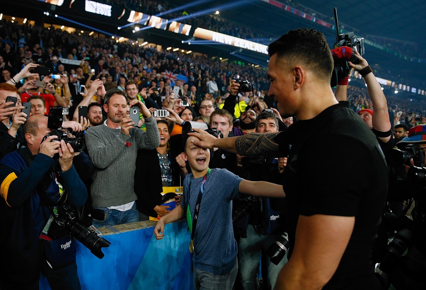 LONDON, ENGLAND - OCTOBER 31:  Sonny Bill Williams of New Zealand gives his winners medal to a young fan following the 2015 Rugby World Cup Final match between New Zealand and Australia at Twickenham Stadium on October 31, 2015 in London, United Kingdom.  (Photo by Mike Hewitt/Getty Images)