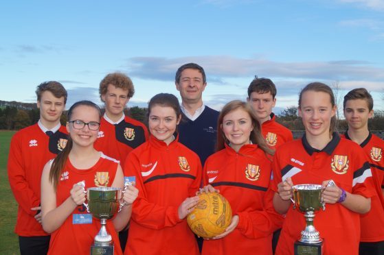 Jonathon Milne, director of the FM group, with Mackie Academy pupils after the firm sponsored the school's new sports kit