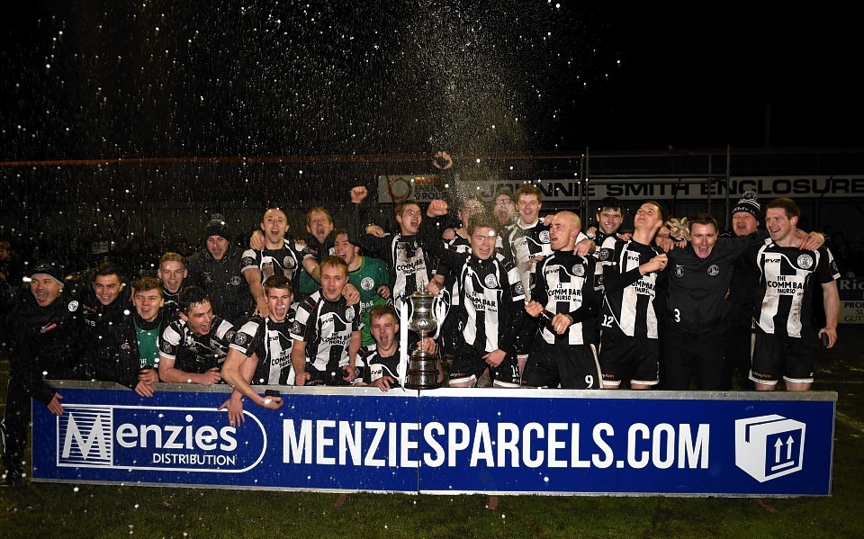Wick Academy players and management lift the cup and enjoy the celebrations. Picture by Gordon Lennox