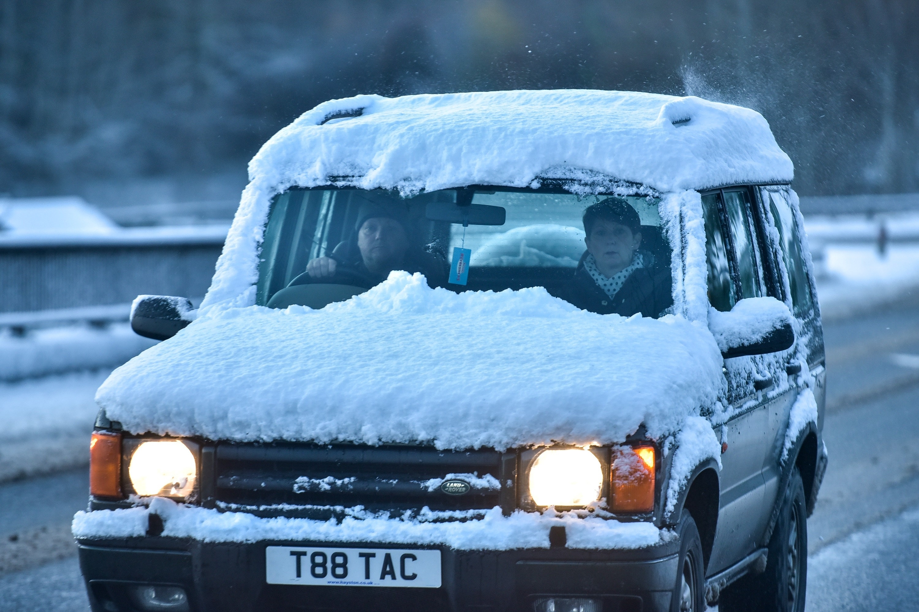 A car covered in snow is seen driving in wintery conditions near Craigellachie, Moray on November 30 2015. Storm Clodagh has brought high winds and snow showers which covered the north of Scotland.