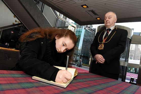 First member of the public to sign a book of condolence for victims of the Paris attacks, Emilie Girard, with Lord Provost George Adam looking on at Aberdeen Town House. Picture by Kevin Emslie