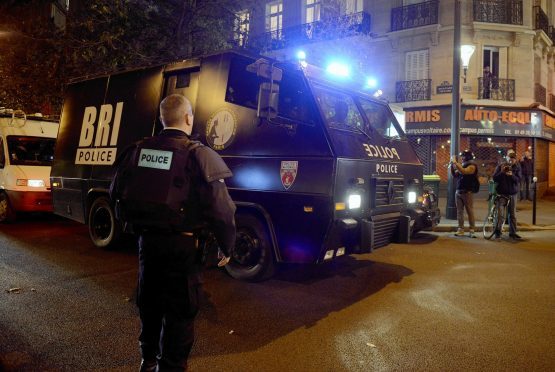 Policemen patrol the streets during gunfire near the Bataclan concert hall