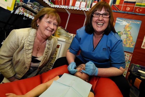 Public health minister Maureen Watt, dental nurse Paula Buchan and Peterhead Central School  Nursery pupil Sophia McAllister