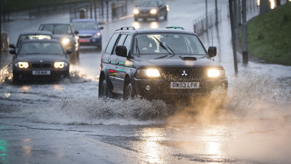 Local flooding on a road in Glasgow as Storm Desmond hits the UK