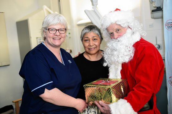 Senior Charge Nurse Caty Smith with Patient Tenny Rolinson who gets a christmas present from Santa on a previous visit to ARI in Ward 114. Picture by Kami Thomson