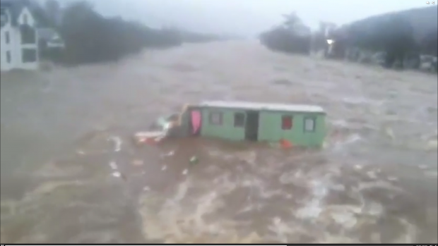 Caravan floating down River Dee, in Ballater, during Storm Frank