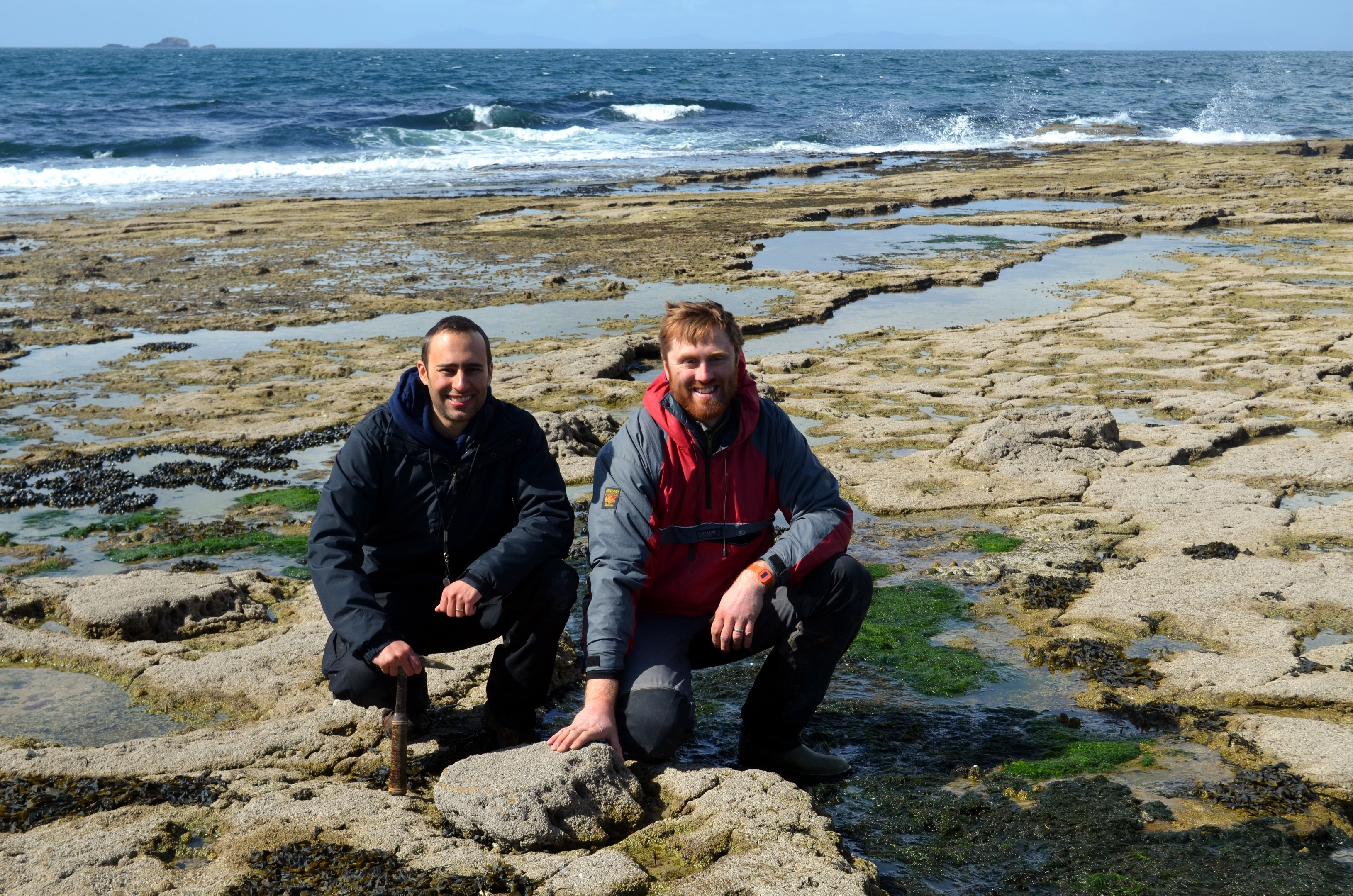 Dr Steve Brusatte (L) and Dr Tom Challands(R) by sauropod dinosaur tracks made 170 million years ago on the Isle of Skye.