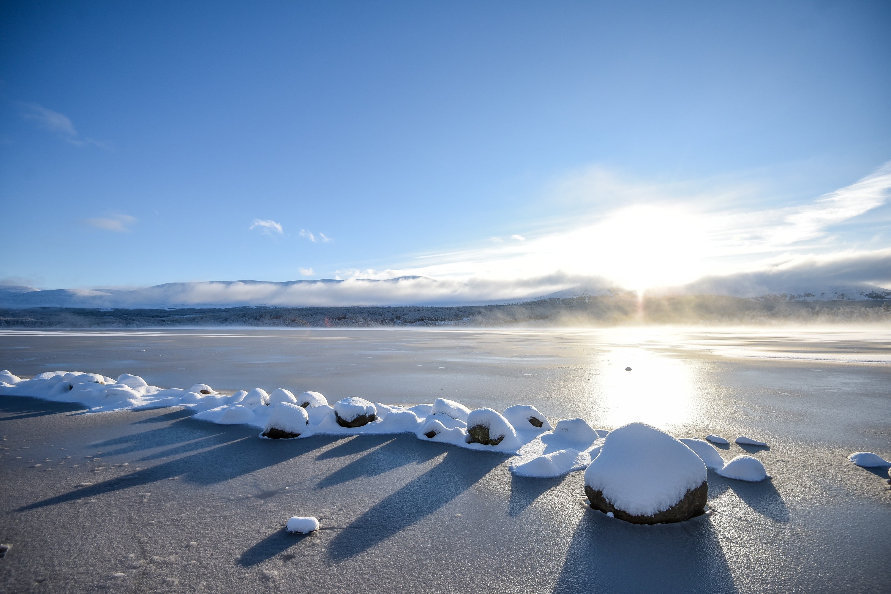 Snow covered rocks sit in a partially frozen Loch Morlich near Aviemore, Scotland on December 14 2015. Last night, Sunday, Scotland's coldest temperature for this Winter was recorded in Dalwhinnie at -8.7C. Up to 15cm of snow fell in Aviemore overnight and local schools were closed.