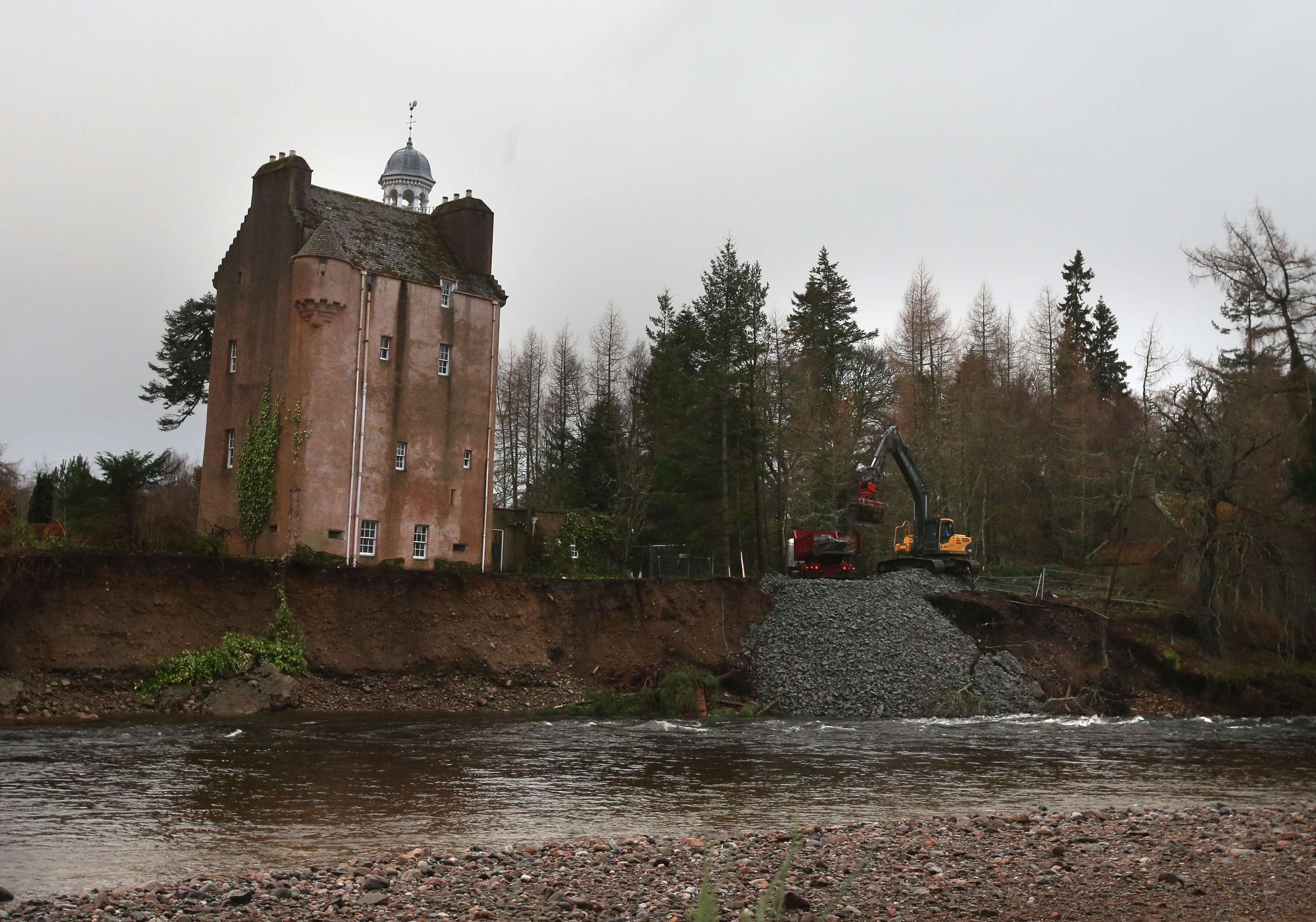 Rocks and boulders are moved to protect the shoreline on the River Dee
