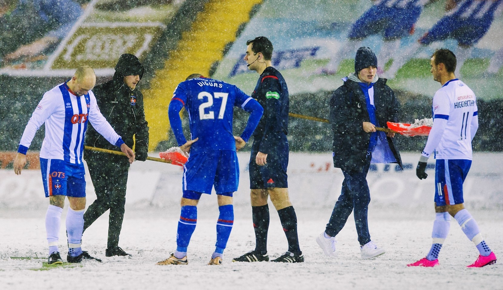Play is stopped as groundsmen attempt to clear the snow again.