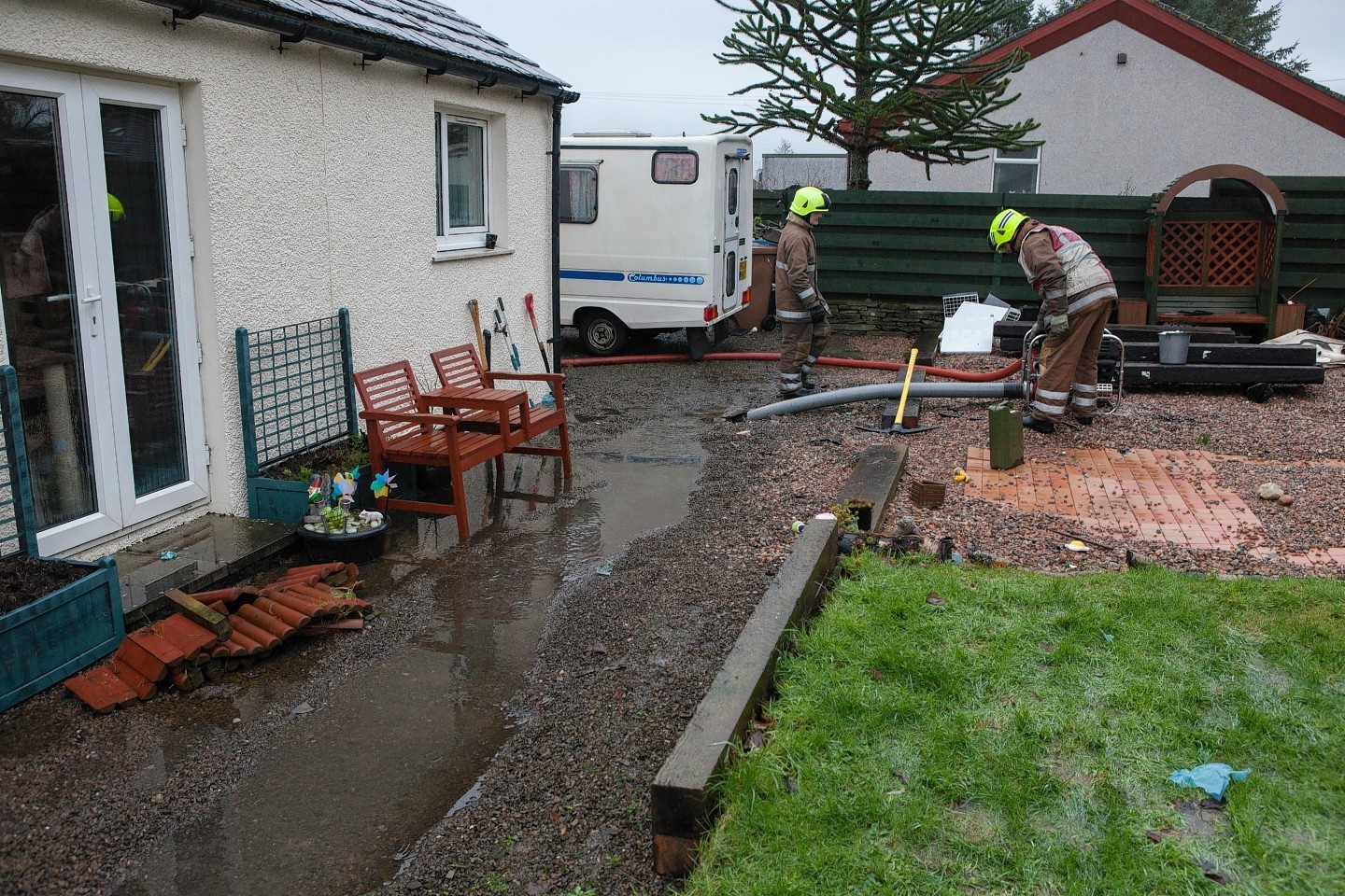 Fire fighters pump a home hit by the floods