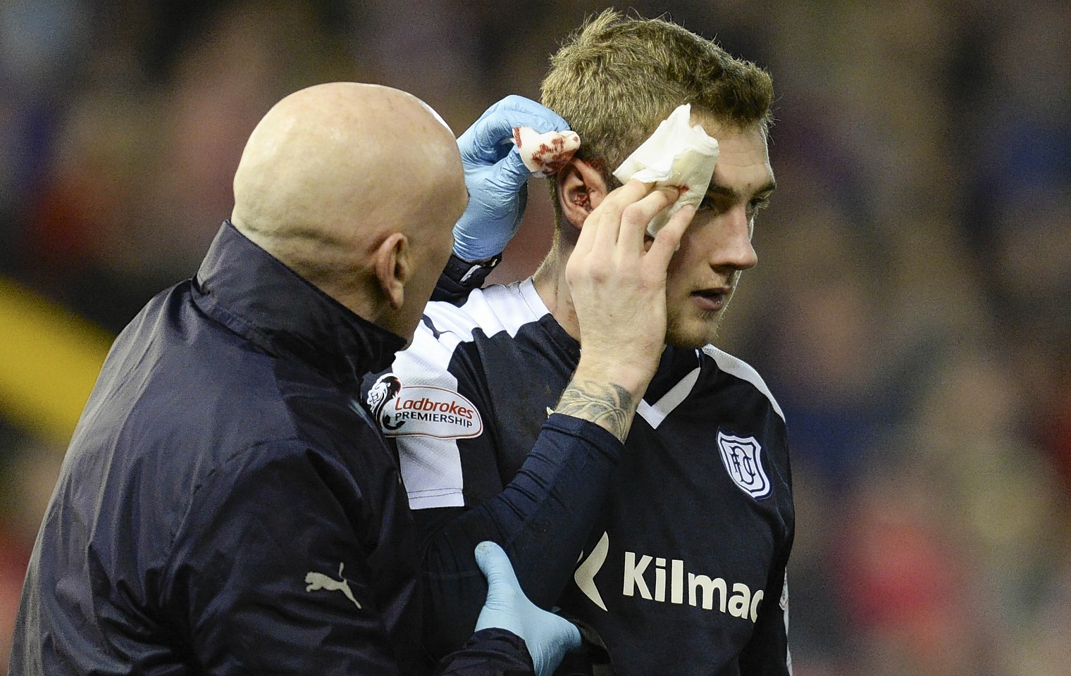 Dundee's Kevin Holt receives treatment after he was caught by a high Shay Logan boot