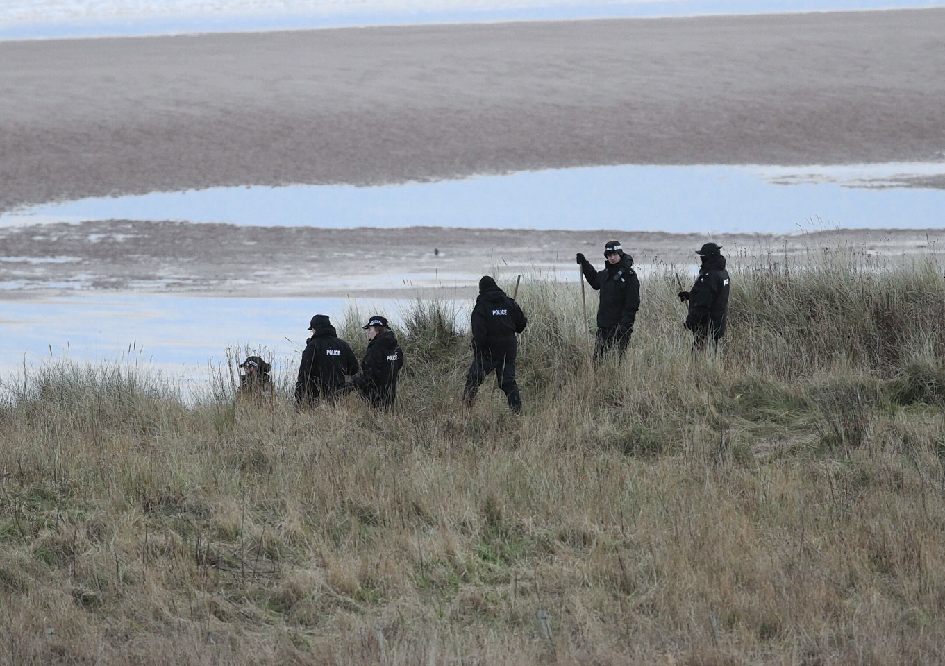 Police search the beach at Lunan Bay 