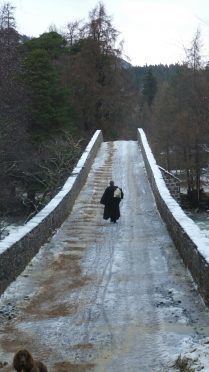The Reverend Ken MacKenzie, of Braemar and Crathie Parish, took to the bridge on his way to deliver a sermon in Crathie this morning. Credit: Simon Blackett.
