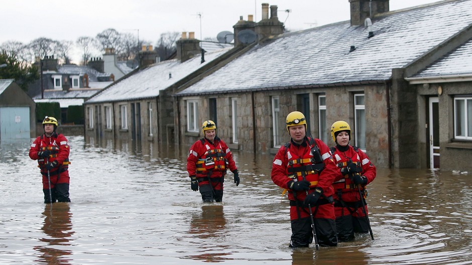 Members of the emergency services wade along Canal Road in Port Elphinstone, near Aberdeen