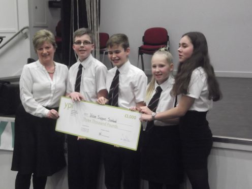 Caption: Portlethen Academy pupils Keir McKechnie, Taylor Lumsden, Calum Graham and Alyssa Hay being handed the cheque for £3,000 for Victim Support Scotland.