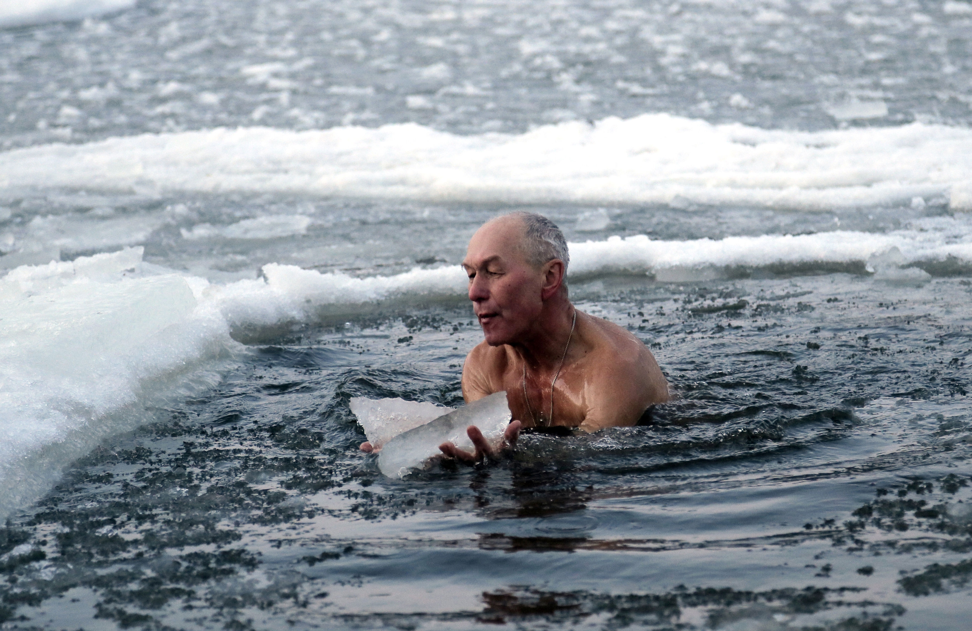 An Orthodox believer plunges in icy water during celebrations of the Epiphany in Kiev, Ukraine, Tuesday, Jan. 19, 2016. Orthodox believers celebrate the holiday of the Epiphany on Jan. 19, and traditionally bathe in holes cut through thick ice on rivers and ponds to cleanse themselves with water deemed holy for the day. (AP Photo/Efrem Lukatsky)